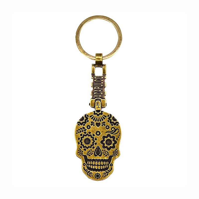 Llavero giratorio de latón en forma de calavera, tradición del día de Muertos en México. Souvenir de Acapulco, México